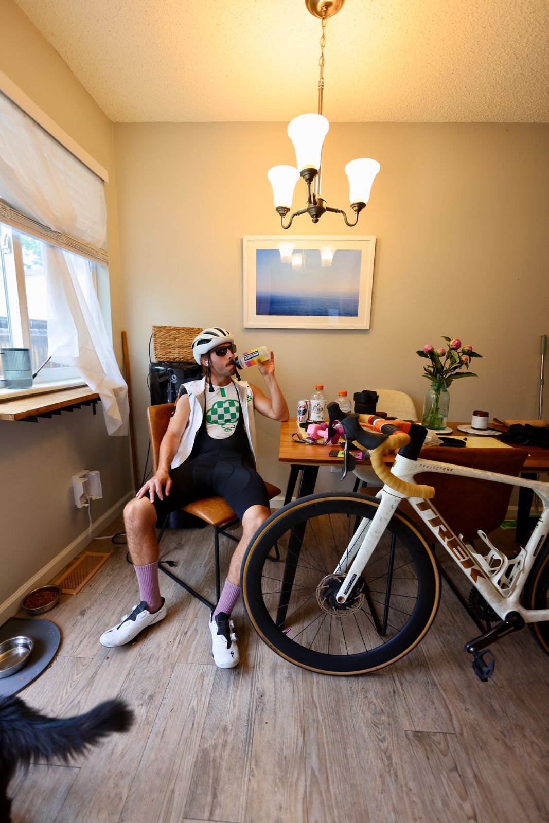 Carter Luense rehydrating at the kitchen table in full kit after a ride