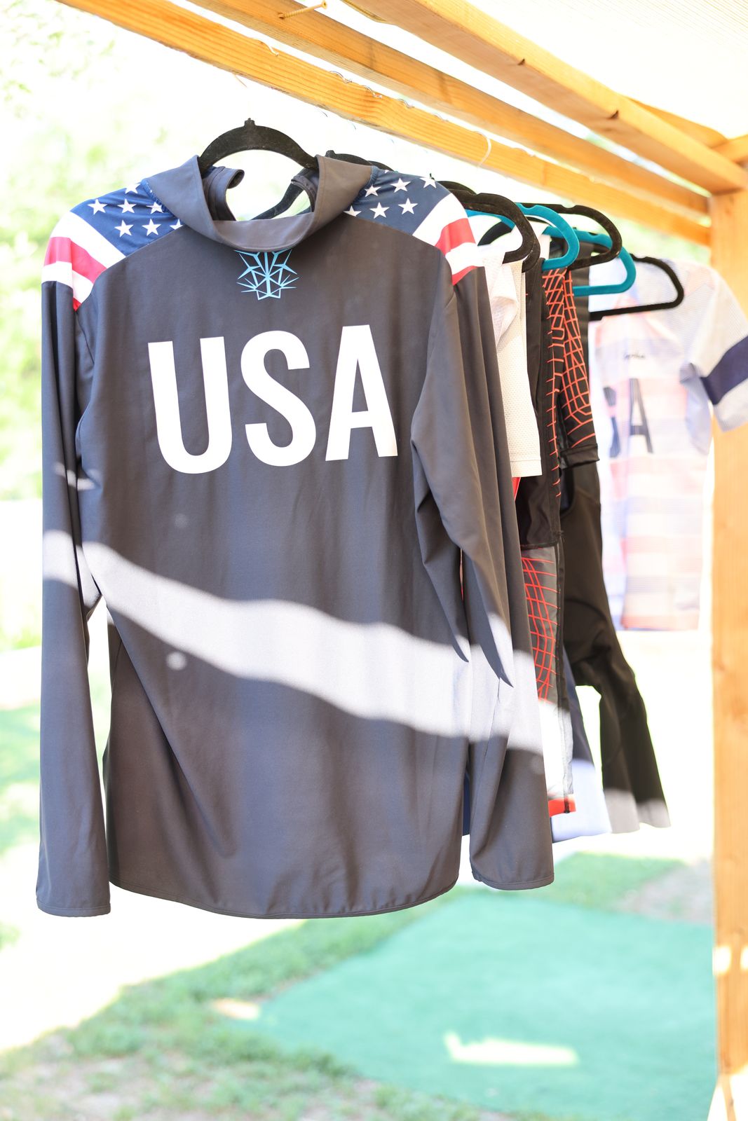 USA kit hanging in a row under the pergola, flag on the shoulders