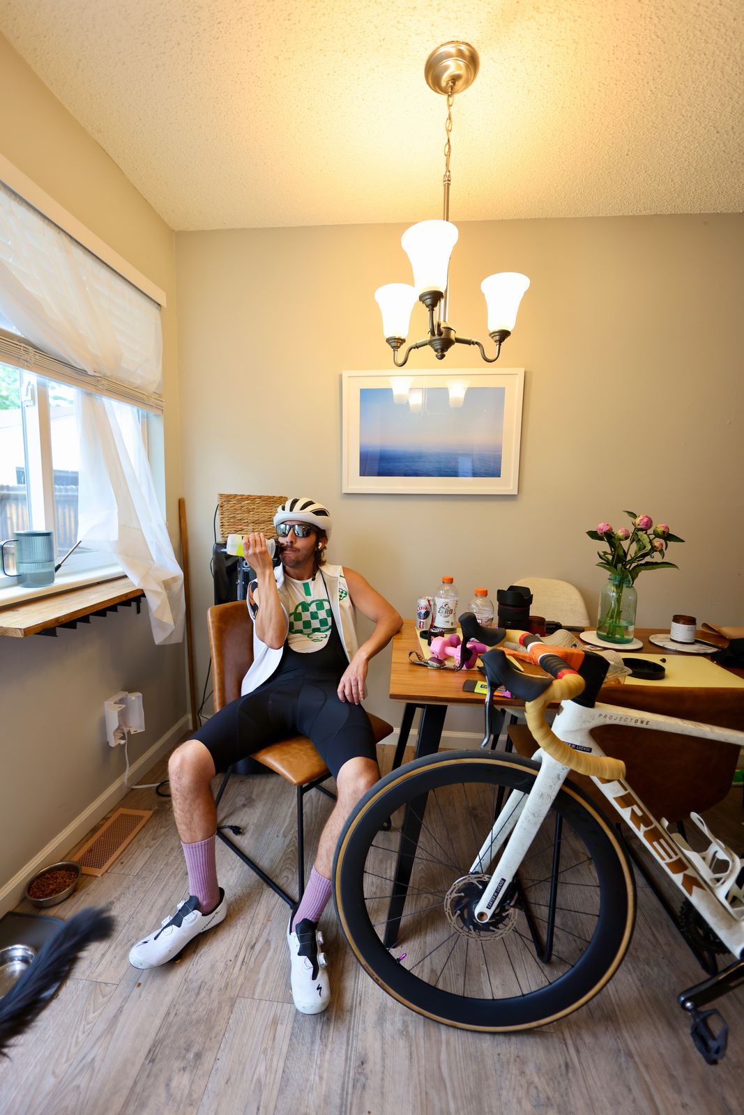 Carter Luense seated post-ride, drinking from a bottle, the white Trek in the foreground