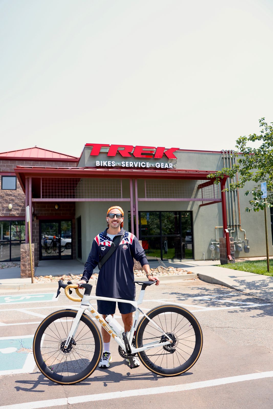 Carter Luense smiling with the white Trek in front of the Trek store