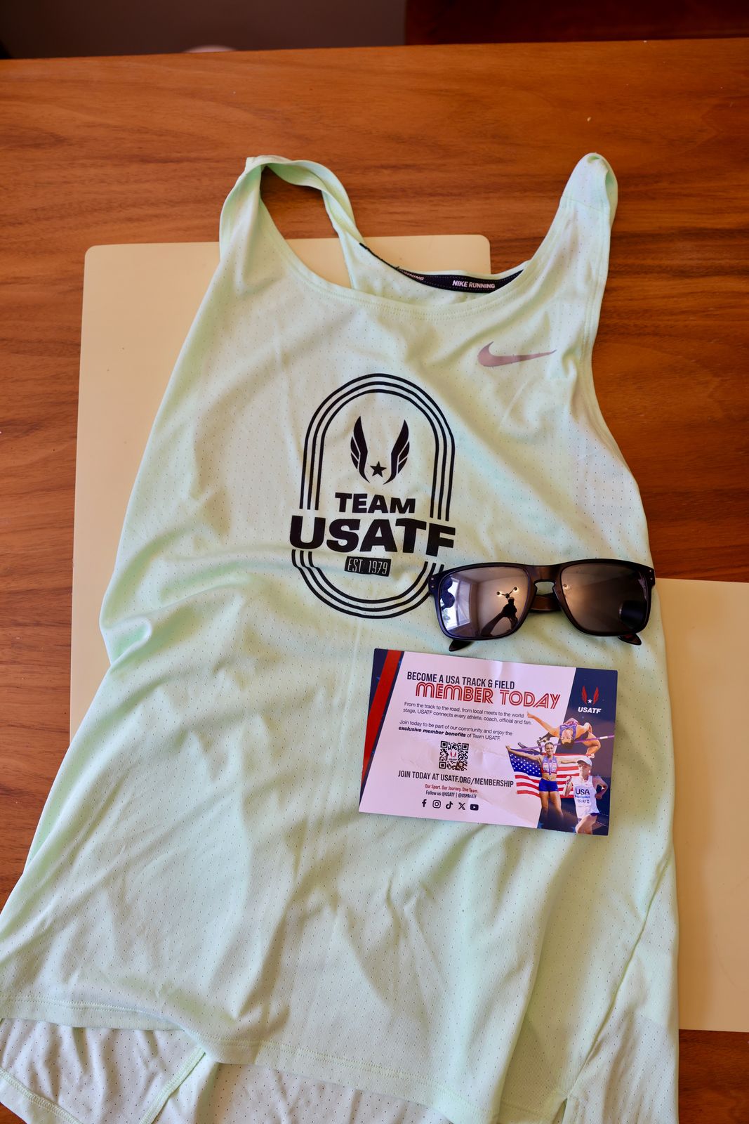 Team USATF singlet laid flat with sunglasses and USATF membership card